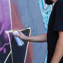 Graffitisprüher besprüht eine Wand