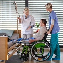 Patient im Rollstuhl in einem Krankenhaus, das eine regelmäßige Sanitärreinigung erhält